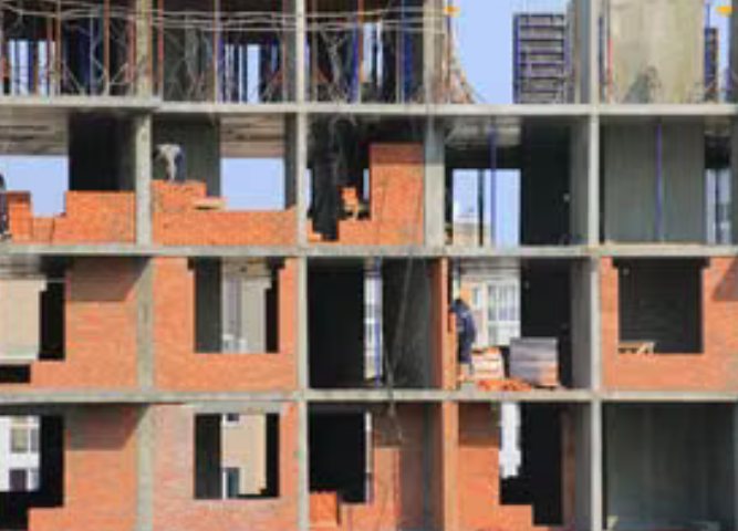 Edificio en obra gris con estructura en concreto y mampostería en ladrillo a la vista
